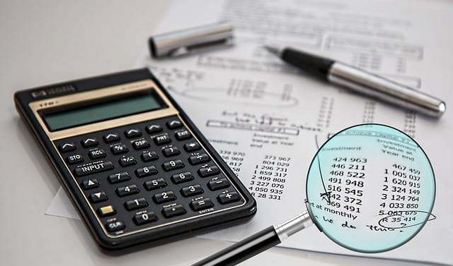Analyse de documents financiers à la loupe lors d'un audit de patrimoine