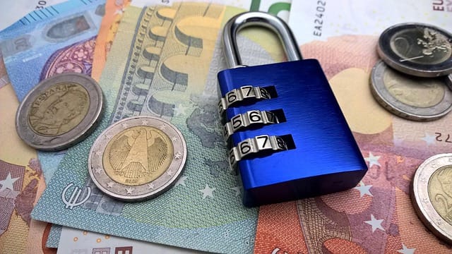 Loi Sapin 2 : cadenas posé sur des billets en euros, symbole du blocage temporaire de l'assurance-vie